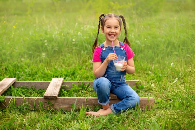 Premium Photo | Smiling girl with pigtails in denim overalls and a pink ...