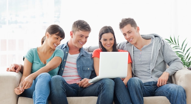 Premium Photo | A smiling group of friends watching a show on the laptop together