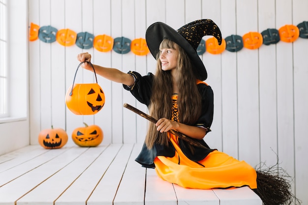 Free Photo | Smiling halloween witch holding jack-o-lantern