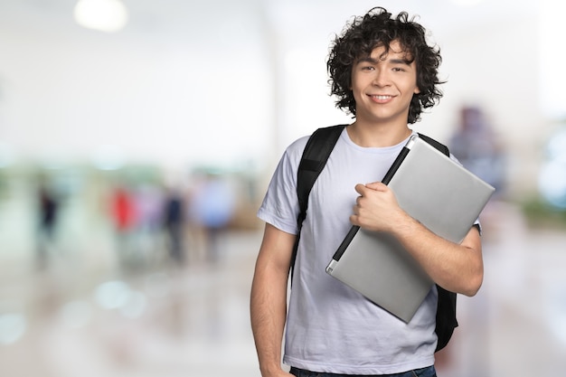 Premium Photo | Smiling handsome boy with laptop on background