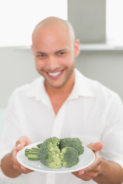 Premium Photo Smiling Handsome Man Holding A Plate Of Broccoli