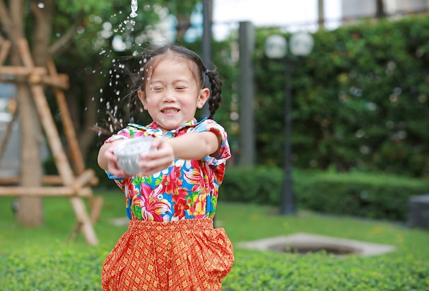 タイの若いアジアのタイ人子供たちを笑顔にして ソンクラーンフェスティバルで水をはねつける プレミアム写真