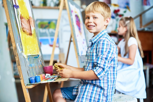 Premium Photo | Smiling little boy in art class