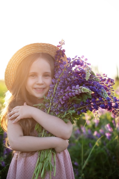 Premium Photo | Smiling little girl with bouquet of lupins a child girl ...