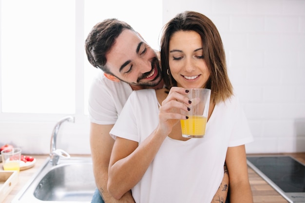 Smiling man hugging woman with juice Free Photo