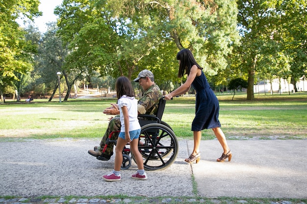 free-photo-smiling-military-man-walking-with-family-in-city-park