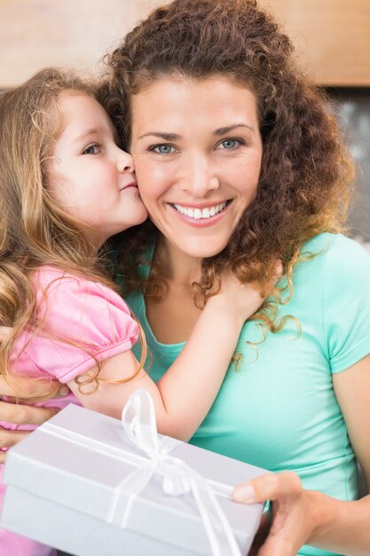 Premium Photo Smiling Mother Getting A Kiss And A Present From Her Daughter 