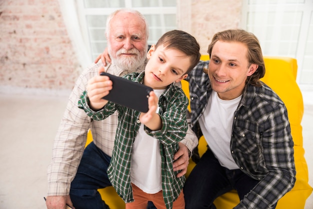 Smiling multi-generational family taking selfie with smartphone Free Photo