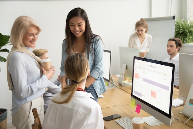 Smiling multiracial businesswomen colleagues of different age talking in office Free Photo