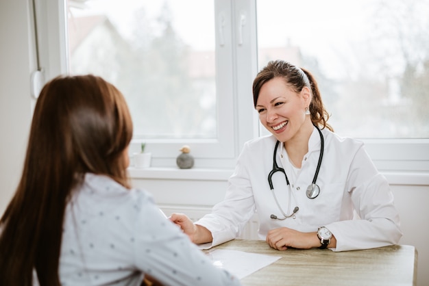 Smiling physician examining client in office. Premium Photo