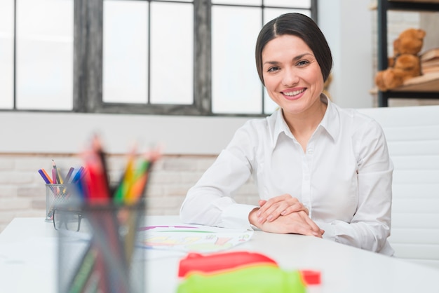 Premium Photo | Smiling portrait of a young confident female psychologist  sitting in her office