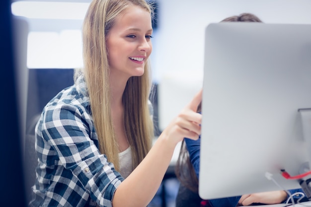 Smiling students using computer at university Photo | Premium Download