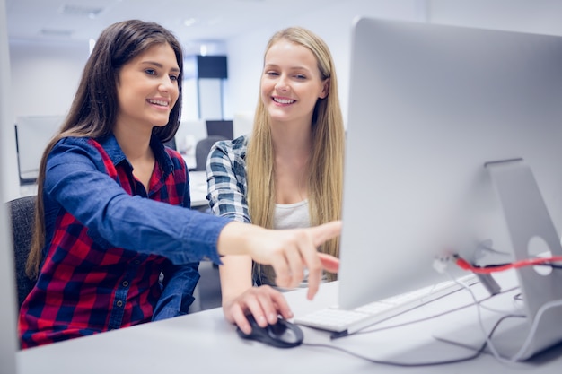 Smiling students using computer at university Photo | Premium Download