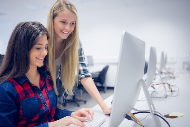 Smiling students using computer at university Photo | Premium Download