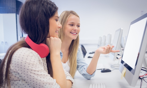 Smiling students using computer at university Photo | Premium Download