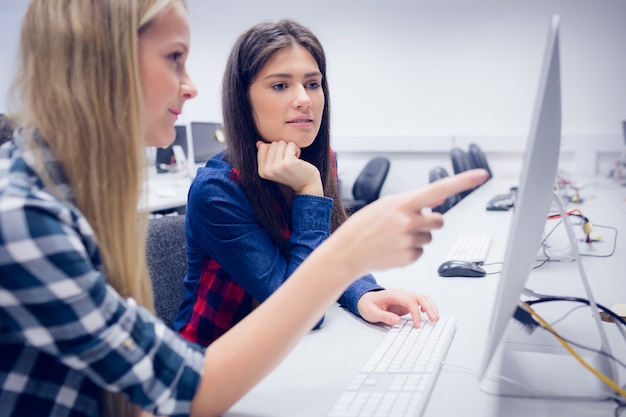 Smiling students working on computer at university Photo | Premium Download