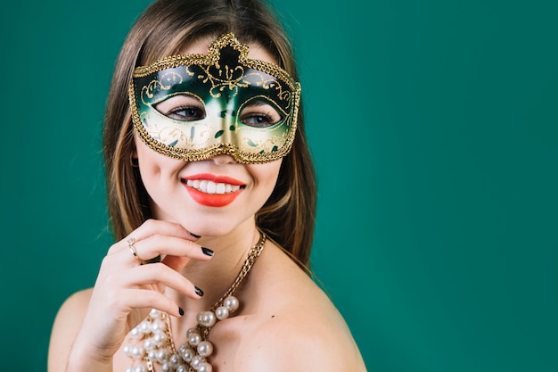 仮面舞踏会カーニバルマスクとネックレスを着てトップレスの女性の笑みを浮かべてください 無料の写真