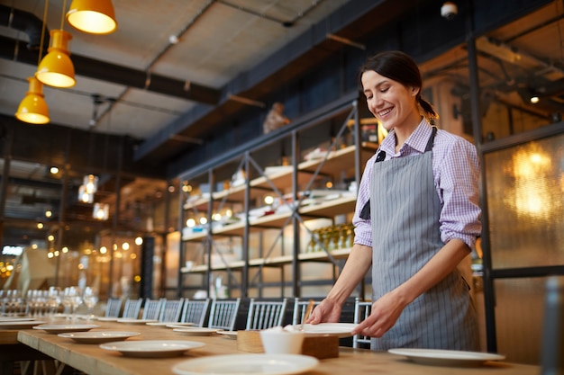 Premium Photo Smiling Waitress Serving Table In Cafe