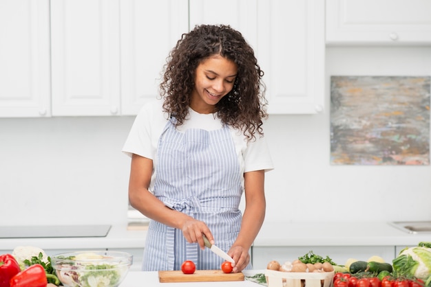 Free Photo | Smiling woman cutting tomatoes