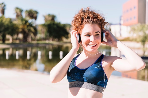 Smiling woman in sportswear enjoying music Free Photo