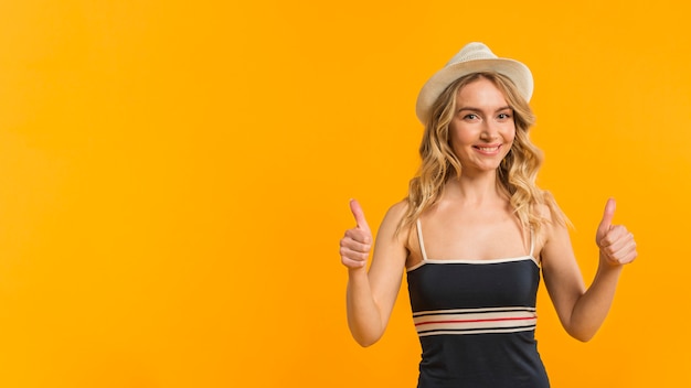 Smiling woman in summer clothes showing thumbs up Free Photo