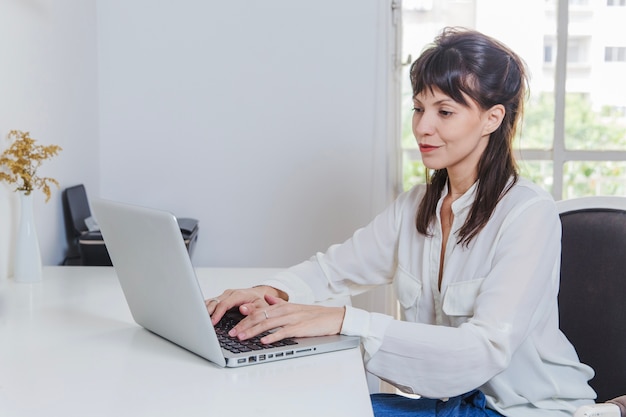 Free Photo | Smiling woman with laptop at desk