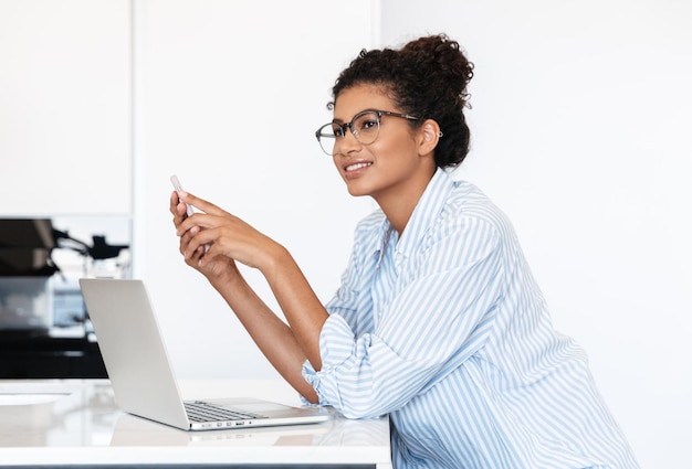 Premium Photo | Smiling young african woman working on laptop computer ...