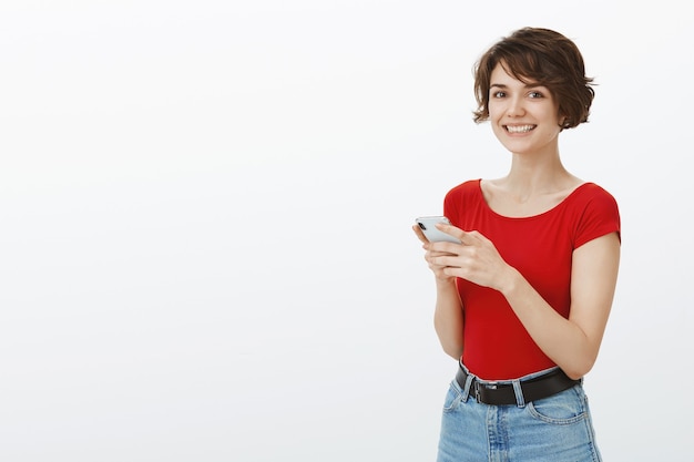 Free Photo | Smiling young attractive woman texting on mobile phone