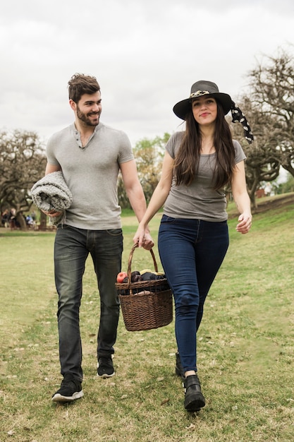  Free  Photo Smiling young couple  walking with picnic 
