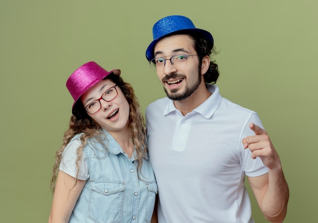 Free Photo | Smiling young couple wearing pink and blue hat guy showing ...