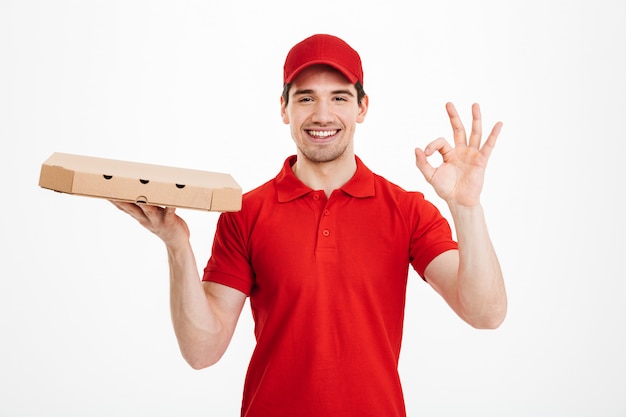 Premium Photo Smiling Young Delivery Man Holding Pizza