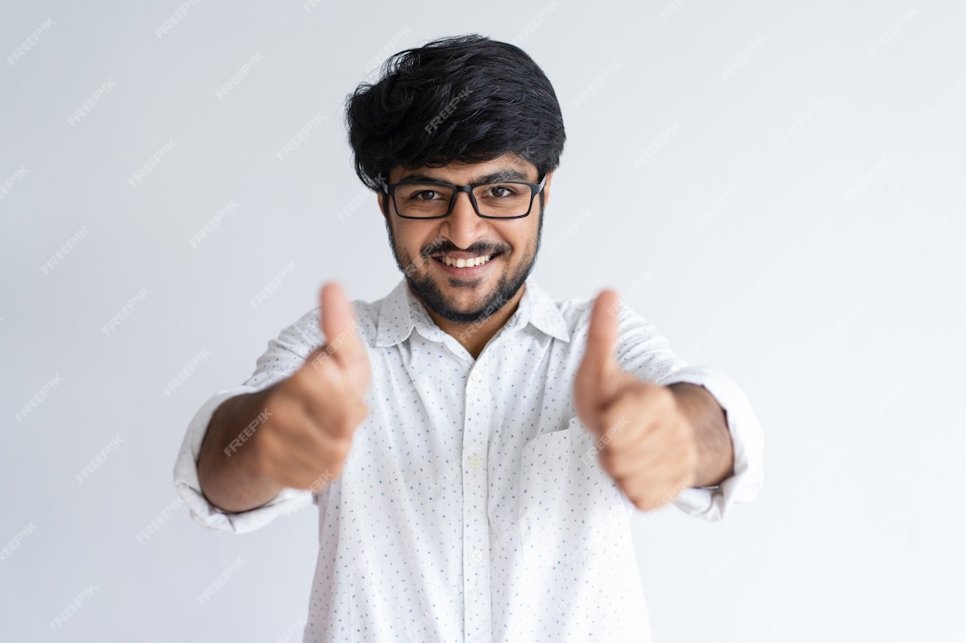 Free Photo | Smiling young indian man showing thumbs up and looking at ...