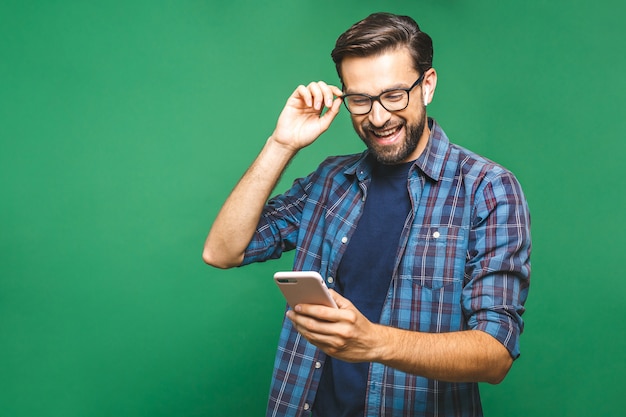 Premium Photo Smiling Young Man Holding Smart Phone And Looking At It