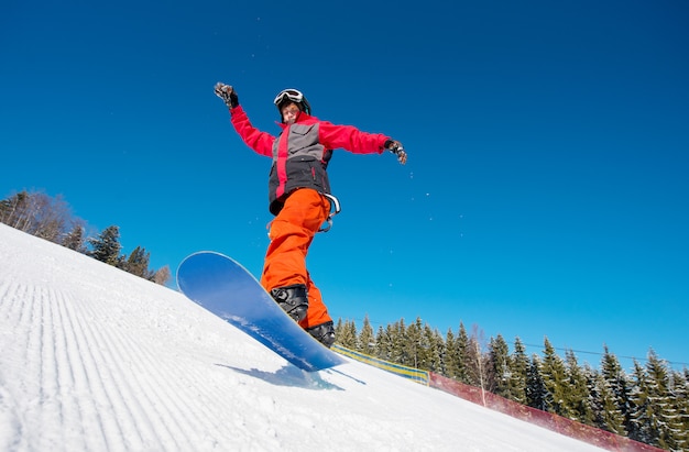 Premium Photo | Snowboarder in the air while riding on the slope in the ...