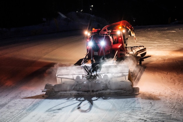 Premium Photo | Snowcat ratrack machine making night snow performance ...