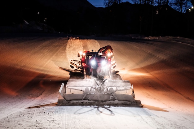 Premium Photo | Snowcat ratrack machine making night snow at ski resort