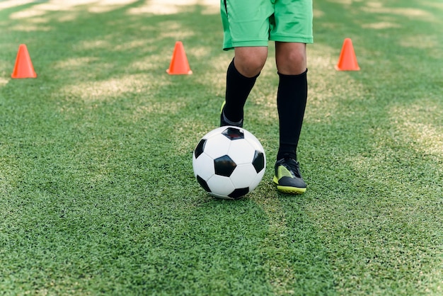 フィールドでボールを蹴るサッカー選手 トレーニングセッションのサッカー選手 プレミアム写真