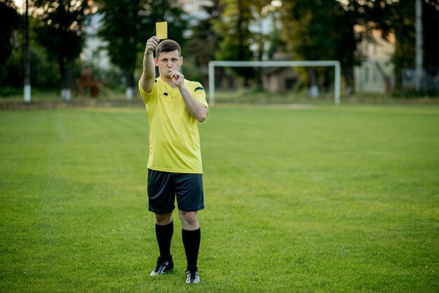 サッカースタジアムの選手にイエローカードを指摘するサッカー審判 プレミアム写真