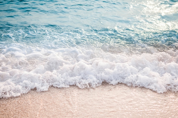 砂浜のビーチで青い海の波 プレミアム写真