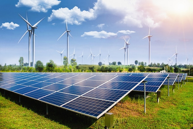 Solar panel with wind turbines against mountains and sky Premium Photo