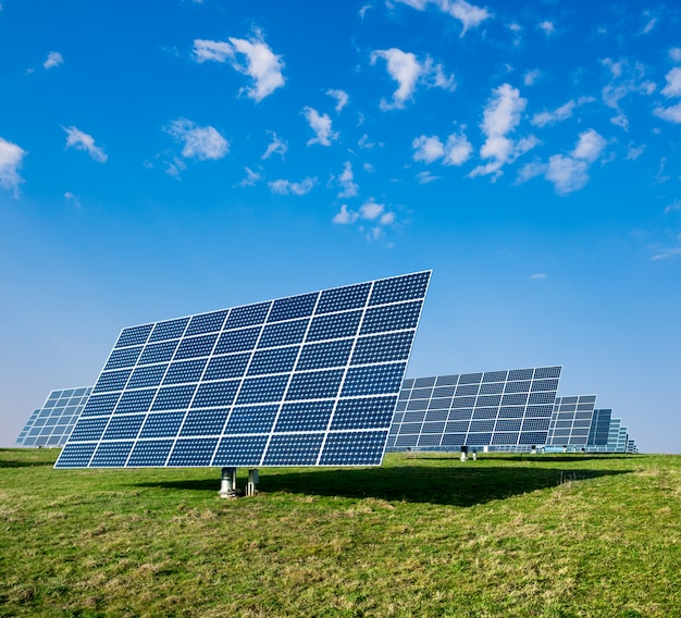 Premium Photo Solar panels on green field and blue sky