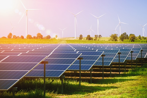 Solar panels and wind turbines generating electricity in power station green energy renewable with blue sky. natural resource conservation concept. Premium Photo