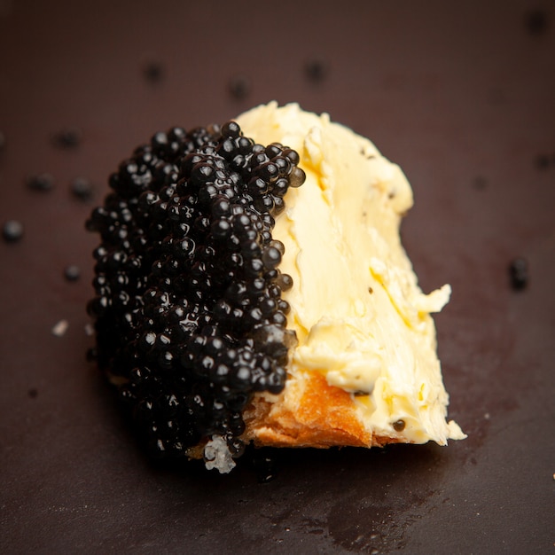 Free Photo | Some black caviar with butter on bread on dark background ...