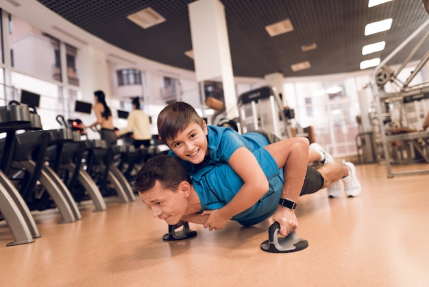 Son is lying on the back of his dad while being wrung out Premium Photo