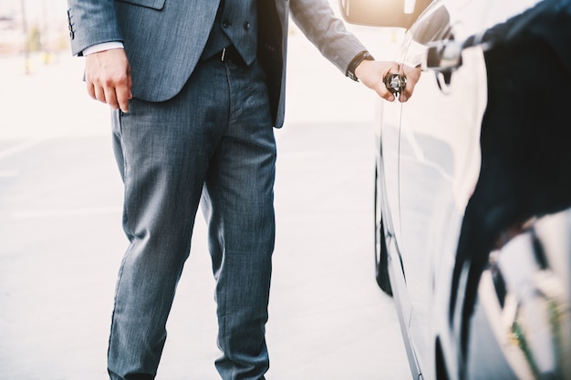 Premium Photo | Sophisticated rich businessman opening his car.