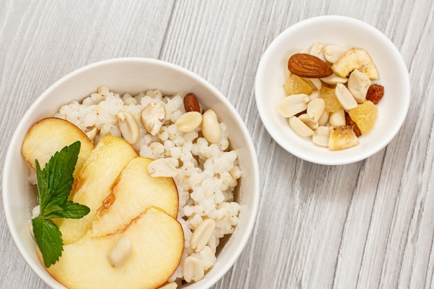 Premium Photo | Sorghum porridge with pieces of peach, cashew nuts and ...