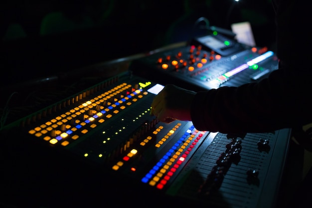 Premium Photo | Soundman working on the mixing console. hands on the ...