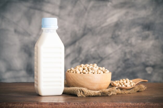 Premium Photo Soy Milk In Bottle And Soybean In Wood Bowl On Wooden Table