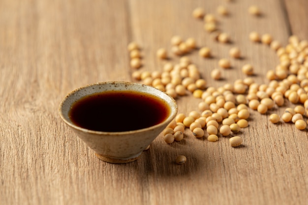 Soybean sauce and soybean on wooden floor soy sauce food nutrition concept. Free Photo