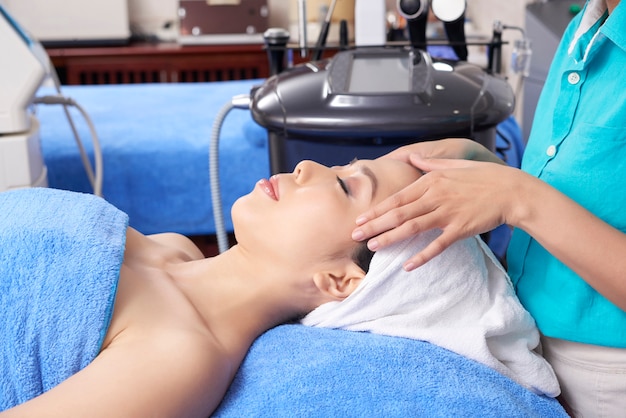 Spa salon worker giving face massage Free Photo